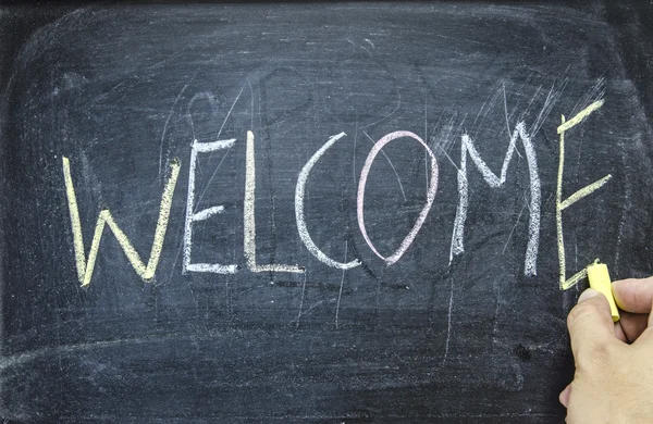 The word "WELCOME" written on blackboard Stock Image