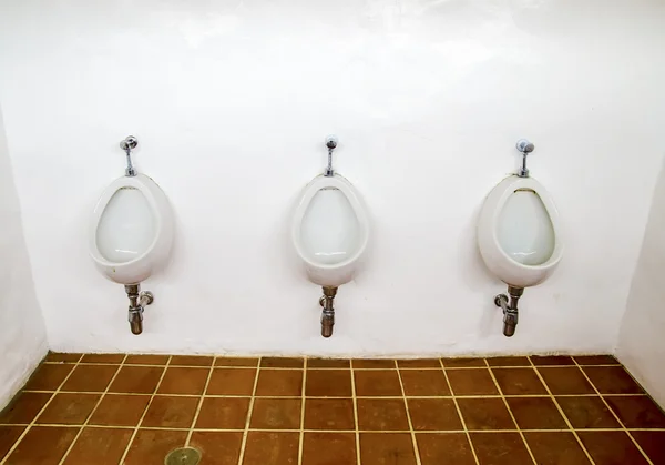 Primer plano de tres urinarios blancos en el baño de hombres — Foto de Stock