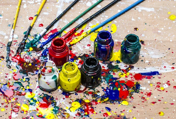 Botella de color y salpicaduras sucias en el escritorio de arte —  Fotos de Stock