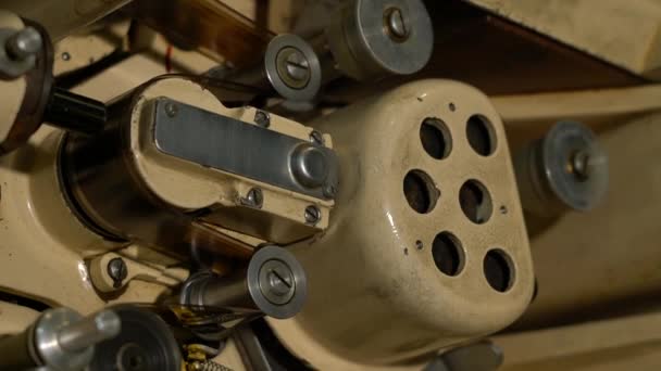 O filme no mecanismo do projetor de filme gira rapidamente em rolos. — Vídeo de Stock