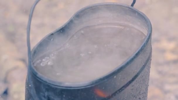 Voda se vaří v tábořišti nad ohněm — Stock video