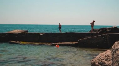 Deniz boyunca beton bir dalgalanma boyunca koşan bir çocuk. Foros, Haziran 2021