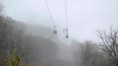Kablolar sisli dağ havasında teleferik boyunca hareket eder.