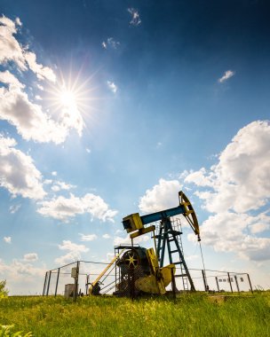 Çalışma petrol kuyusu dramatik bulutlu gökyüzü üzerinde profilli