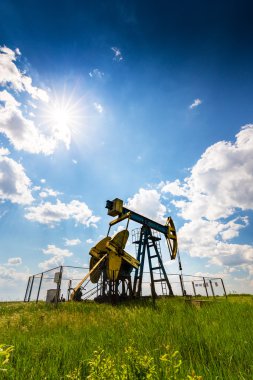 Çalışma petrol kuyusu dramatik bulutlu gökyüzü üzerinde profilli