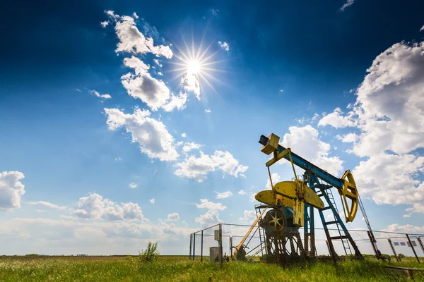 Çalışma petrol kuyusu dramatik bulutlu gökyüzü üzerinde profilli