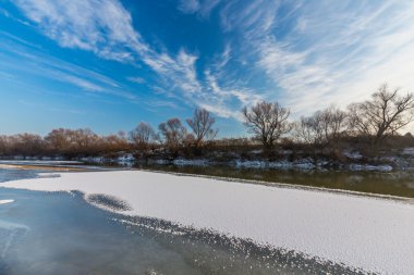 Kapsamındaki Frost ağaçlar ve gündoğumu, kışın donmuş nehir