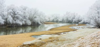 Winter scenery in remote rural area in Europe, with frost covered fields and country road