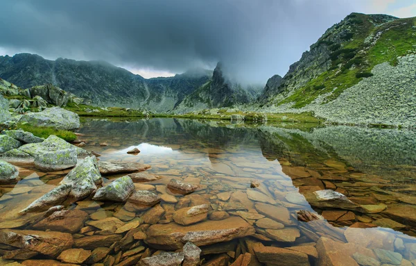 Альпийский пейзаж в Альпах, с облаками заката и ледниковым озером — стоковое фото