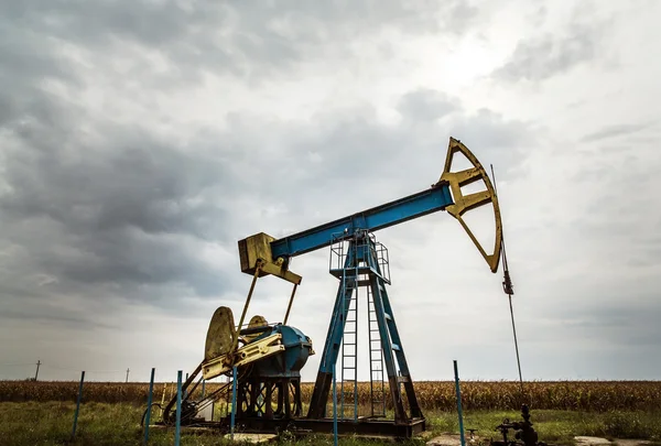 Puits de pétrole et de gaz profilés sur ciel dramatique — Photo