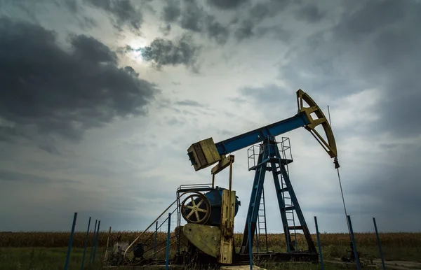 Oil and gas well profiled on dramatic sky — Stock Photo, Image
