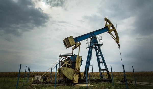 Puits de pétrole et de gaz profilés sur ciel dramatique — Photo