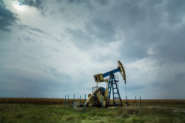 Puits de pétrole et de gaz profilés sur ciel dramatique — Photo