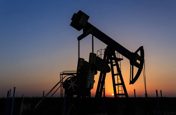 Oil and gas well silhouette in remote rural area — Stock Photo, Image