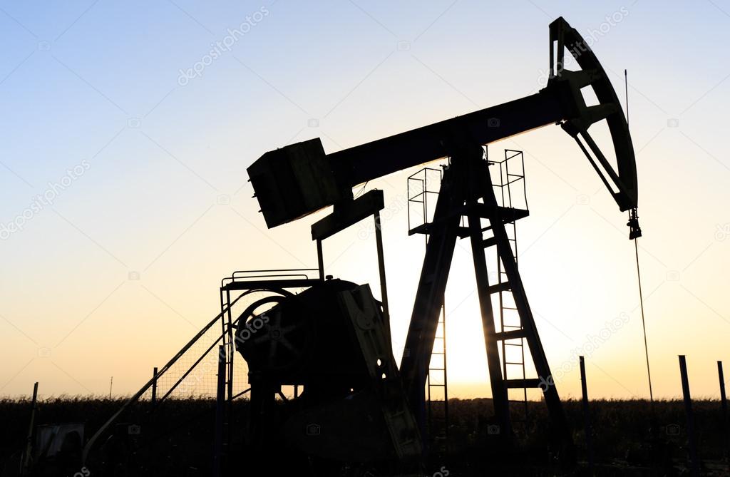 Oil and gas well silhouette in remote rural area