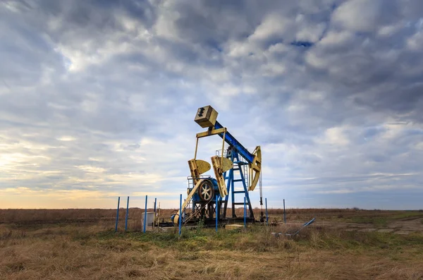 Operación de petróleo y gas bien perfilado en el cielo puesta de sol —  Fotos de Stock