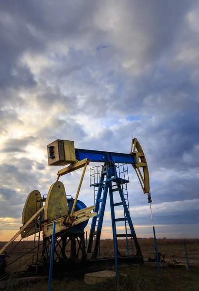 Funzionamento di petrolio e gas ben profilato sul cielo al tramonto — Foto Stock