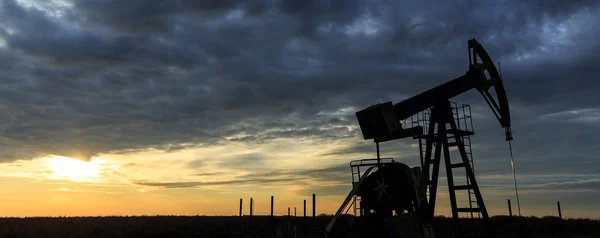 Bomba de pozo de petróleo y gas industrial al atardecer — Foto de Stock