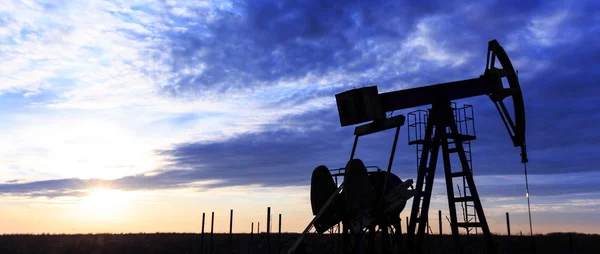 Industrielle Öl- und Gasbrunnenpumpe bei Sonnenuntergang — Stockfoto