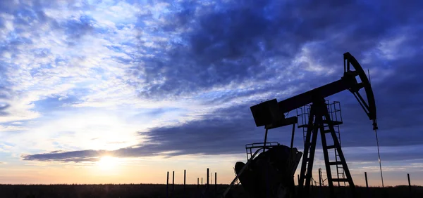 Industrial oil and gas well pump at sunset — Stock Photo, Image
