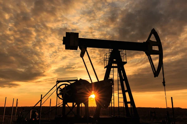 Pompa industriale per pozzi di petrolio e gas al tramonto — Foto Stock