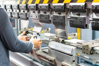 Yarı otomatik hidrolik bükme makinesinin dişlerini kapat ve teknisyenin elleri bükme sırasında metal levhayı ya da iş parçasını yakala..