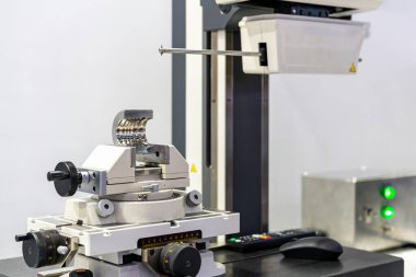 Yüzey pürüzü ve kontur ölçüm makinesi teftişi sırasında mengeneye ayarlanmış makine parçası veya ürün