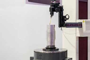Teftiş sırasında ve denetim sırasında yuvarlaklık silindiri ve düzlük ölçüm makinesi üzerinde çalışma döner tablosuna yerleştirilmiş silindirik metal parçası