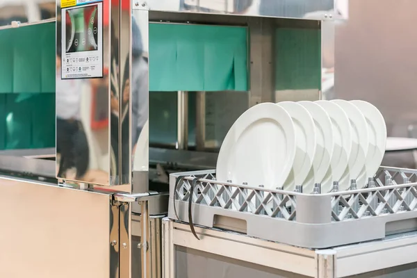 厨房餐厅用自动洗碗机清洗篮子里的许多白盘 — 图库照片
