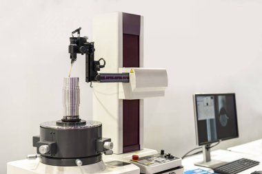 Teftiş sırasında ve denetim sırasında yuvarlaklık silindiri ve düzlük ölçüm makinesi üzerinde çalışma döner tablosuna yerleştirilmiş silindirik metal parçası