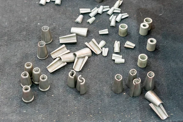 Various size sample metal workpiece After forming production or machining shape conical, cylinder, and made a internal thread cut for separate sections on the carpet.
