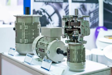 cross section show metal cogs helical gear bearing housing shaft and other detail inside of  transmissions gearbox for industrial assembly with electric induction motor