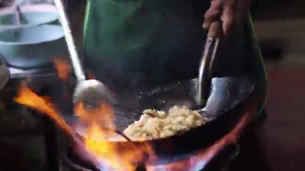 Уличная еда шеф-повар приготовления пищи в черной кастрюле с огнем в Yoawarat Road Бангкок Таиланд — стоковое видео
