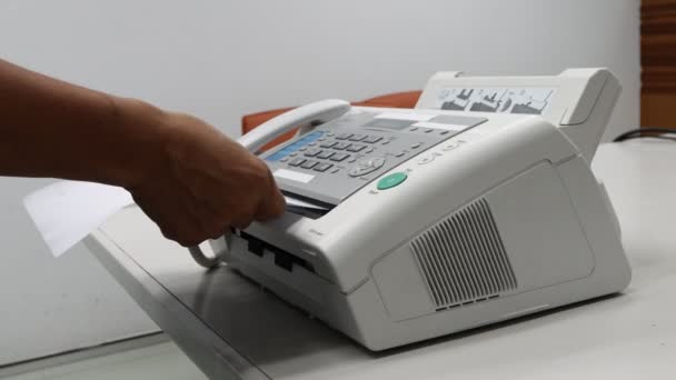手の男はオフィスでファックス機を使っていますデータ伝送のための機器 — ストック動画