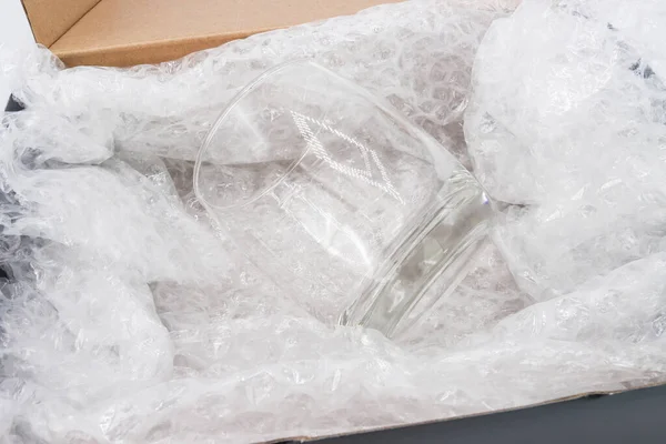 バブルラップは 輸送中に破損した製品や保険を保護するために箱に水ガラスをカバー — ストック写真