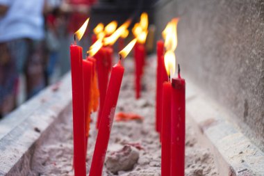 Tayland 'da Buda dininin önemli gününde çimento tapınak sembollerinde kırmızı mumlar..
