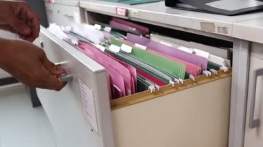 İş yerindeki bir dosya dolabındaki Man Search dosyaları, konsept ofis hayatı.