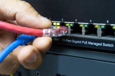 Technician connect cable network to switch port in server room , Concept internet network managemen clipart