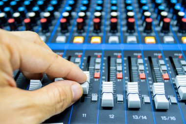 Erkeklerin elleri büyük bir yüksek kurgu sisteminin konsolunu kontrol ediyor. Ses ekipmanı. Dijital bir stüdyonun kontrol paneli 