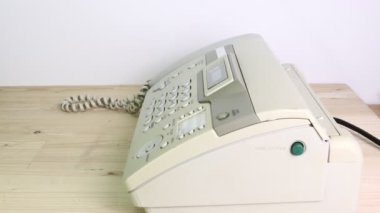 Eleman ofiste faks makinesi kullanıyor. Veri transferi için ekipman..