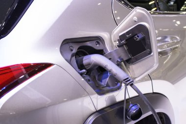 Aracın aküsünü şarj etmek yeni otomotiv yenilikleri şarj edilen elektrikli bir arabaya takılan güç kaynağı, enerji yeniliği kavramı..