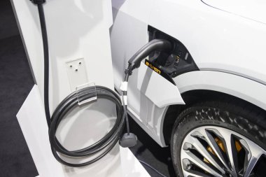 Aracın aküsünü şarj etmek yeni otomotiv yenilikleri şarj edilen elektrikli bir arabaya takılan güç kaynağı, enerji yeniliği kavramı..