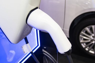 Aracın aküsünü şarj etmek yeni otomotiv yenilikleri şarj edilen elektrikli bir arabaya takılan güç kaynağı, enerji yeniliği kavramı..