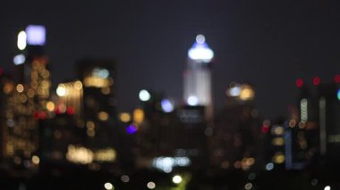 Bulanık video, yüksek binalar ve şehir manzarasının arkasından ay yükseliyor.