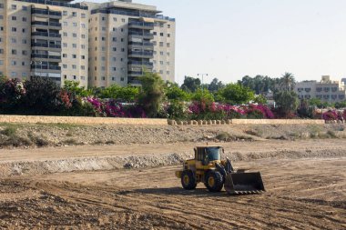  Yeni binaların yakınındaki şantiyede çalışan büyük traktörün görüntüsü 