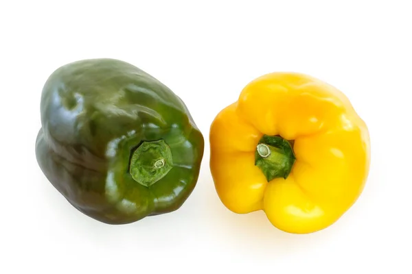Two bell peppers, green and yellow, laying on a flat surface, isolated on white background with a clipping path.