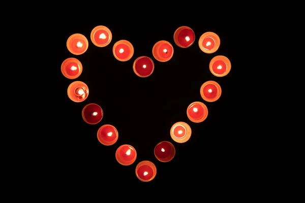 Red burning candles in the shape of a heart on a black background. Valentines day concept. Top view. — Stock Photo, Image