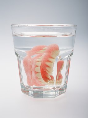 A set of dentures in a glass of water clipart