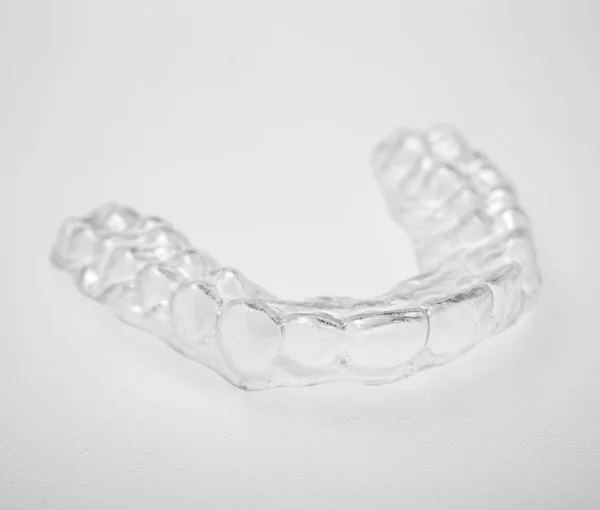 Translucent essix retainer on a gray background — Stock Photo, Image