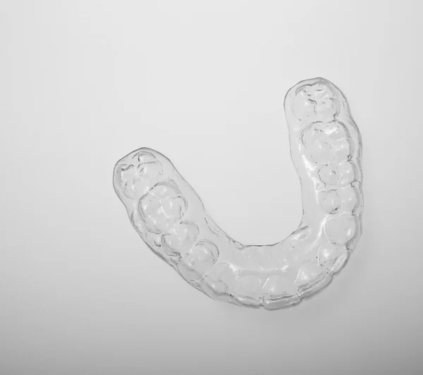 Translucent essix retainer on a gray background — Stock Photo, Image